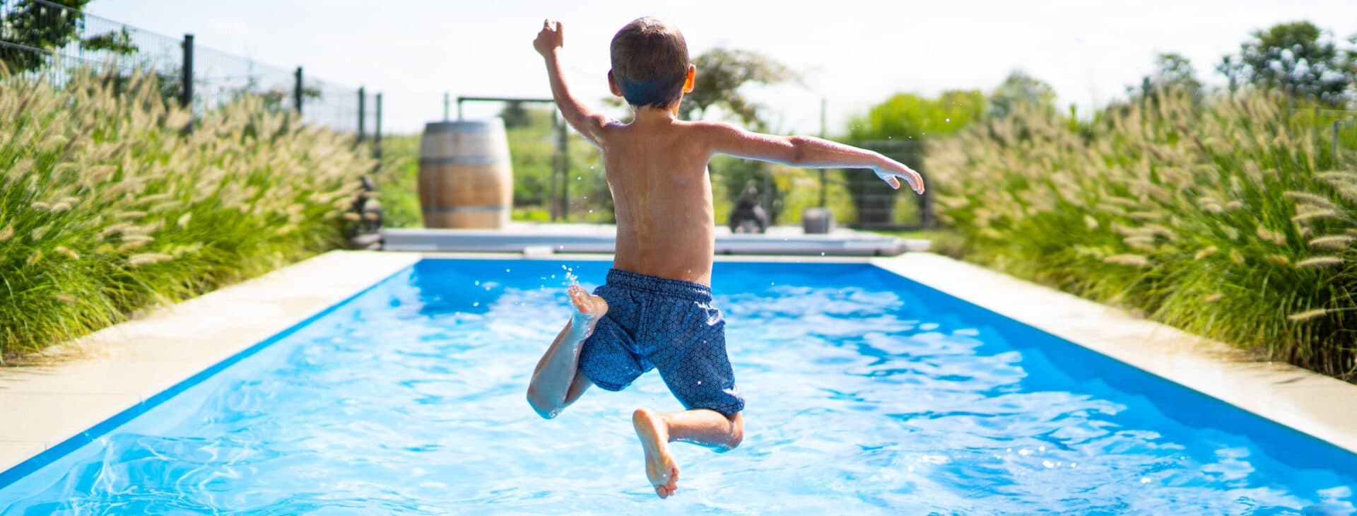 hello summer holidays – boy jumping in swimming pool